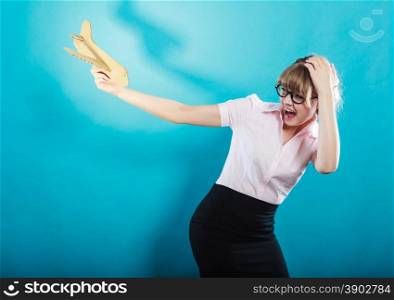 Fly fear metaphor, aerophobia concept. Business woman holding airplane in hand vivid blue background