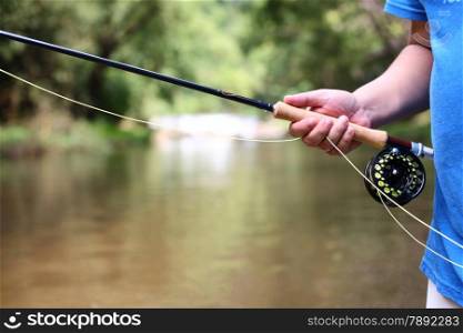 fly fishing rod in hand.