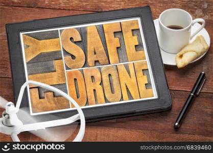 fly safe drone - word abstract in vintage letterpress wood type on a digital tablet with a drone propeller and coffee