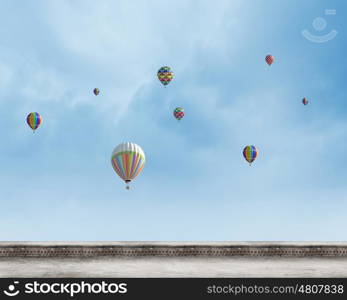 Flying aerostats. Colorful balloons flying high in blue sky