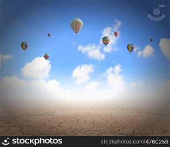 Flying aerostats. Colorful balloons flying high in blue sky above desert