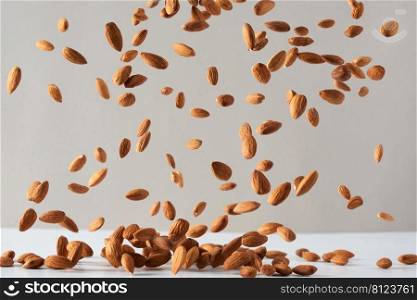 Flying almond nuts. Fresh raw almonds fall on a white background.Flying almond nuts. Fresh raw almonds fall on a white background.