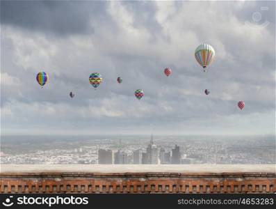Flying balloons. Colorful aerostats flying in clear sky above modern city