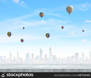 Flying balloons. Colorful aerostats flying in clear sky above modern city