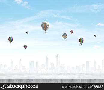 Flying balloons. Colorful aerostats flying in clear sky above modern city