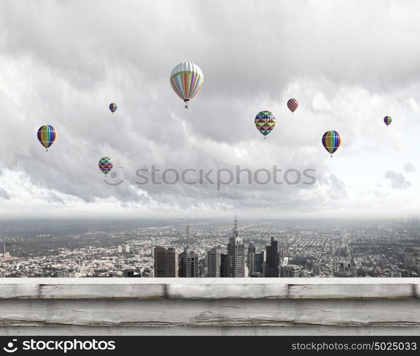 Flying balloons. Colorful aerostats flying in clear sky above modern city