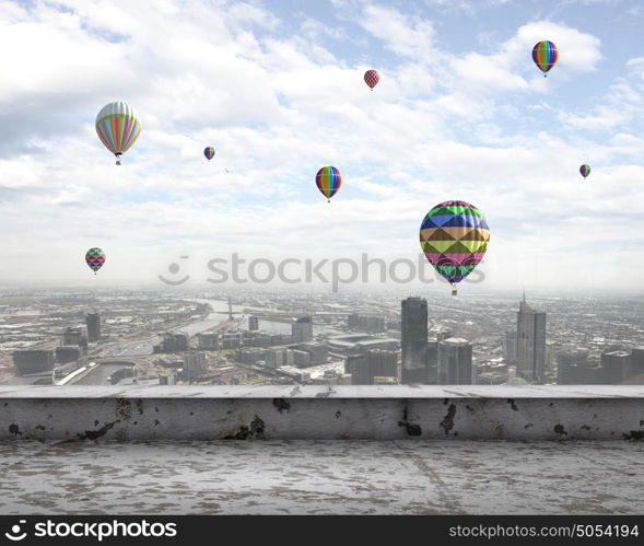 Flying balloons. Colorful aerostats flying in clear sky above modern city