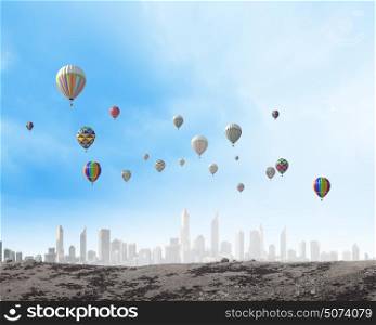 Flying balloons. Colorful aerostats flying in clear sky above modern city
