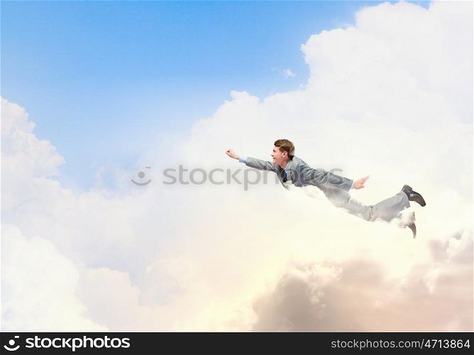 Flying businessman. Young businessman superhero flying high in sky