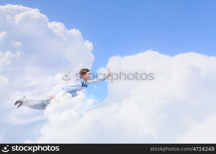 Flying businessman. Young businessman superhero flying high in sky