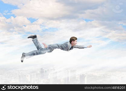 Flying businessman. Young businessman superhero flying high in sky