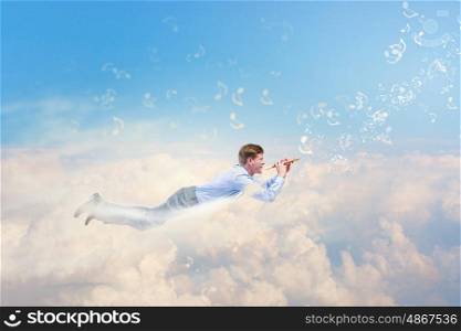 Flying businessman. Young man flying in sky and playing fife