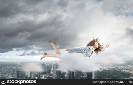 Flying businesswoman. Young determined businesswoman flying high in sky