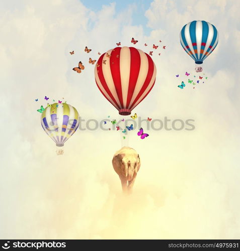 Flying elephant. Sunny image of elephant flying in sky on aerostat