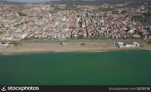Flying from the sea to the city. Barcelona coast and dense housing, Spain