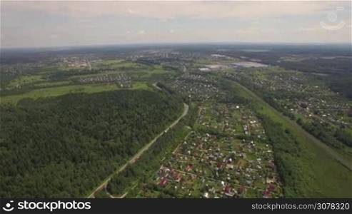 Flying over the territory with green woods and summer houses, Russia
