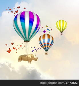 Flying rhino. Rhino flying high in sky on colorful aerostat