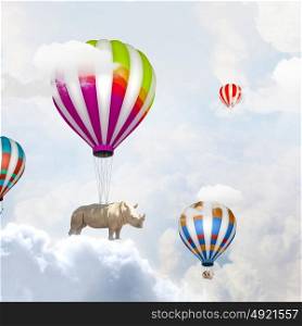 Flying rhino. Rhino flying high in sky on colorful aerostat