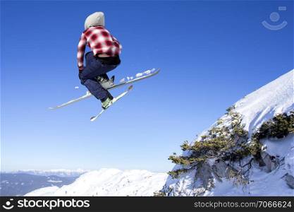 Flying skier at jump inhigh on snowy mountains. Extreme winter sport.