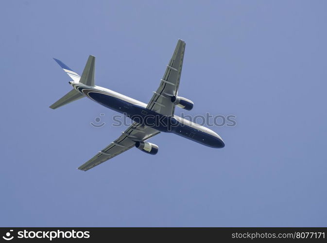 Flying white plane on blue sky background