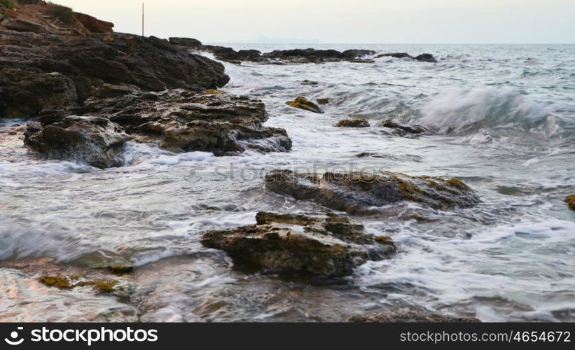 foam waves splash at stones on shore sea