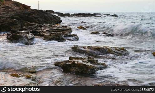 foam waves splash at stones on shore sea