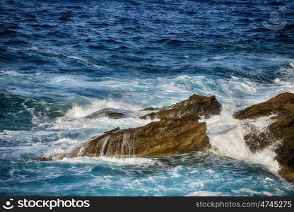 foam waves splash at stones on shore sea