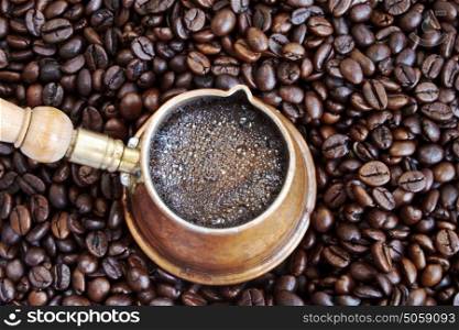 Foaming coffee in an arab copper coffee pot