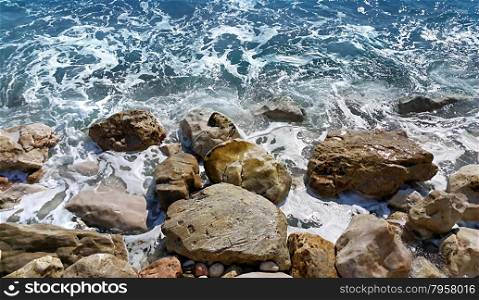 Foamy sea water near a rocky shore