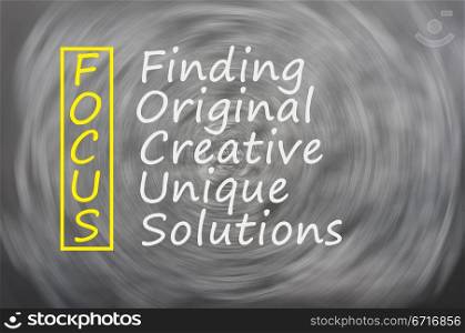 Focus acronym for Finding,Original,Creative,Unique,Solutions written on a blackboard