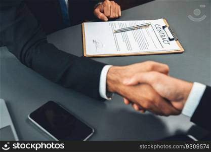 Focus business contract paper with blur background of handshake after successfully close business deal, sealing partnership agreement. Legal document and handshaking as formal agreement. Fervent. Focus business contract paper with blur background of handshake. Fervent