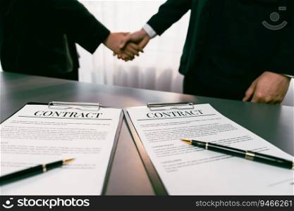 Focus closeup panorama business contract paper with pen, while two professionals shake hand in blurred background, signifying successful negotiation and partnership agreement with handshaking. Prodigy. Focus closeup business contract paper with pen with blur handshaking. Prodigy