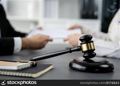 Focus closeup wooden gavel on blur background of lawyer colleagues or drafting legal documents on their workplace at law firm office. Hammer of justice for righteous and equality judgment. Equilibrium. Focus closeup wooden gavel on blur background of legal team. Equilibrium
