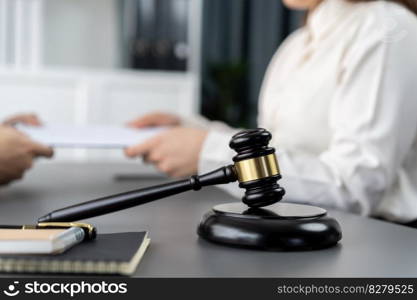 Focus closeup wooden gavel on blur background of lawyer colleagues or drafting legal documents on their workplace at law firm office. Hammer of justice for righteous and equality judgment. Equilibrium. Focus closeup wooden gavel on blur background of legal team. Equilibrium