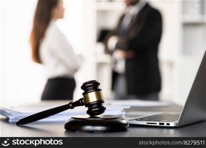 Focus closeup wooden gavel on blurred background of lawyer colleagues or legal team working at law firm office. Hammer of justice for righteous and equality judgment. Equilibrium. Focus closeup wooden gavel on blur background of legal team. Equilibrium