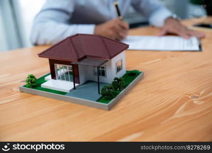 Focus house s&le house model with blurred satisfied buyer sign house loan or purchase agreement with smile, finalizing the deal in the background with real estate agent or landlord. Fervent. Focus house s&le house model with blurred satisfied signing contract. Fervent