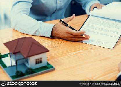 Focus house s&le house model with blurred satisfied buyer sign house loan or purchase agreement with smile, finalizing the deal in the background with real estate agent or landlord. Fervent. Focus house s&le house model with blurred satisfied signing contract. Fervent