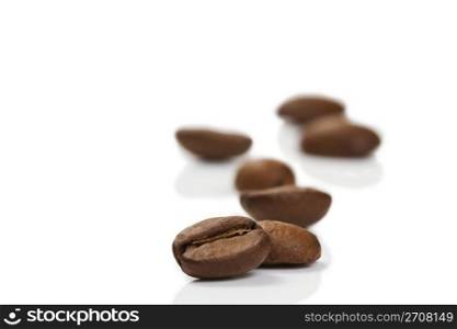 focus on a coffee bean in front of others. focus on a coffee bean in front of others on white background
