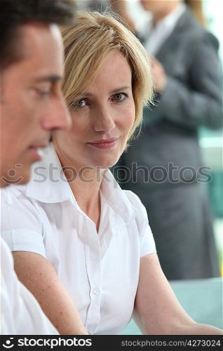 Focus on a woman sitting with colleagues