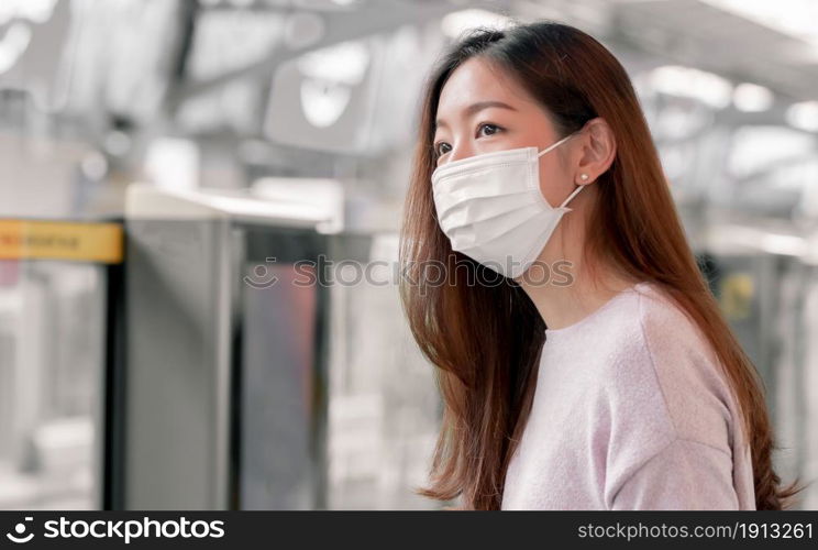 Focus on asian woman wearing mask to protect virus while using public transportation. New Normal Concept.