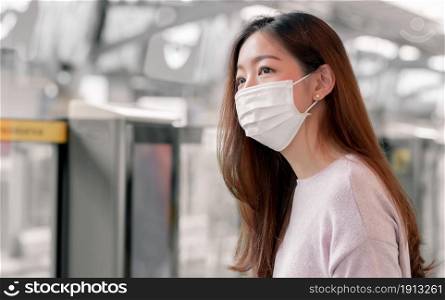 Focus on asian woman wearing mask to protect virus while using public transportation. New Normal Concept.