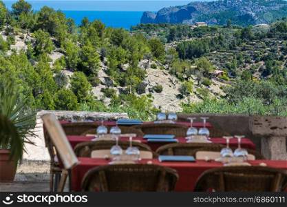 Focus on background.Tables and chairs of a romantic secretive restaurant on the coast of the island of Mallorca, Spain.