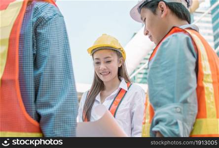 Focus on female engineer smiling and looking draft at paper for project planning. Engineering concept.