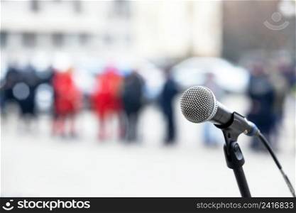 Focus on microphone, blurred crowd of people in the background