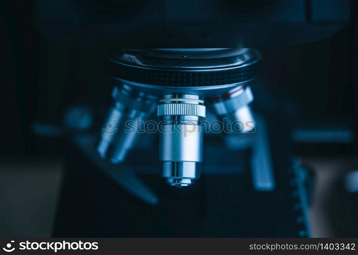Focus on microscope with metal lens for experiments, educational demonstrations in clinical laboratories. Medicine researching concept. Blurred background