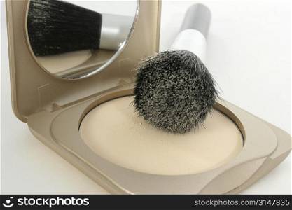 Focus on powder. Brush laying on compact.