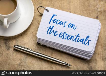 Focus on the essentials - reminder on a stack of index cards with a cup of coffee