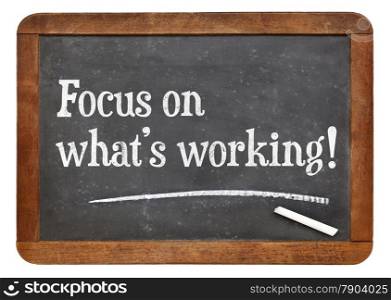 Focus on what is working. Motivational words on a vintage slate blackboard.