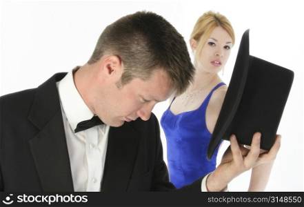 Focus on woman. Beautiful young woman in blue formal looking at camera behind attractive young man in tux.