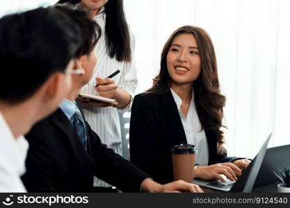 Focus portrait of female manger, businesswoman in the harmony meeting room with blurred of colleagues working together, analyzing financial paper report and dashboard data in background.. Focus portrait of asian female manger with blurred colleague figures in harmony.